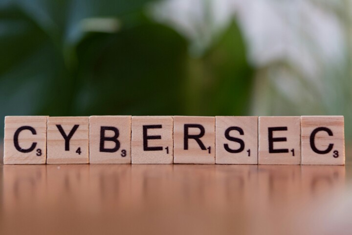 Wooden letter tiles spelling CYBERSEC, representing cybersecurity in software testing and AI security.